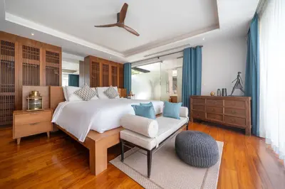 a bedroom with a large bed and a chair at Villa love with a garden in Phuket