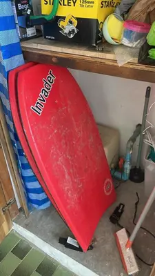 a red surfboard sitting on top of a shelf at The Lighthouse Seaview Hotel in Rawai Beach