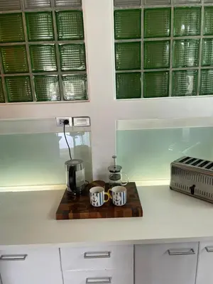 two coffee mugs on a wooden tray on a kitchen counter at The Lighthouse Seaview Hotel in Rawai Beach