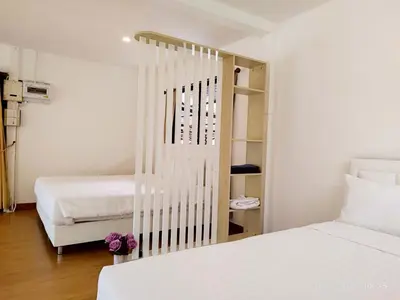 a bedroom with two beds and a book shelf at Suan Tha-Thong Homestay in Ban Bang Pla
