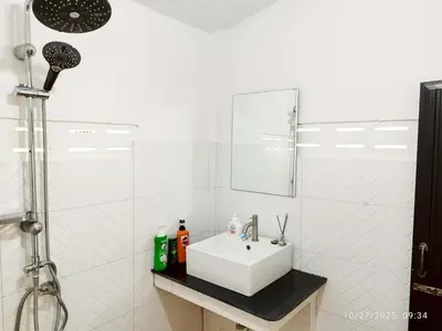 a white bathroom with a sink and a mirror at Suan Tha-Thong Homestay in Ban Bang Pla