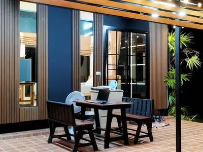 a table and two chairs with a laptop on it at Suan Tha-Thong Homestay in Ban Bang Pla