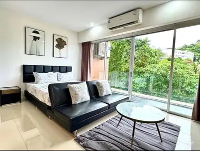 a bedroom with a bed and a couch and a table at Chic condominimum in Karon Beach
