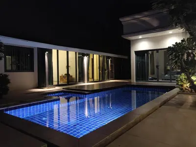 a swimming pool in front of a house at night at 4-Bedroom cozy pool villa in the heart of Bang Tao in Laguna Phuket