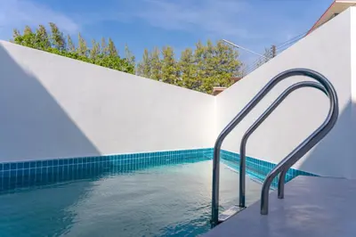 a swimming pool with a hand rail in the water at BangTao 5 Bedrooms 2026 New Modern Private Pool Villa Great Location Close to Bangtao Beach in Ban Thalat Choeng Thale