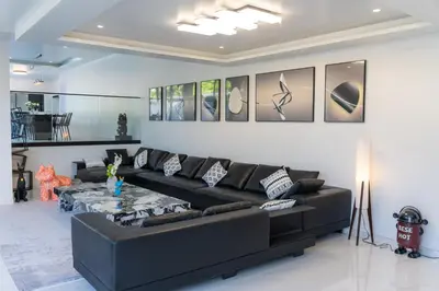 a living room with a black couch and a table at BangTao 5 Bedrooms 2026 New Modern Private Pool Villa Great Location Close to Bangtao Beach in Ban Thalat Choeng Thale