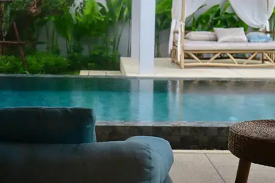 a swimming pool with a couch and a chair next to it at Botanica Four Season Luxury Pool Villa in Phuket