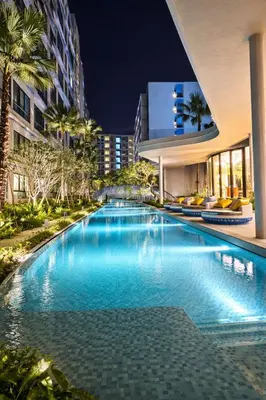 a swimming pool in front of a building at night at Modern Apartment with Pool & Gym in Kathu