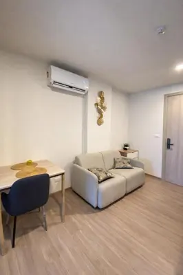 a living room with a couch and a table at Modern Apartment with Pool & Gym in Kathu