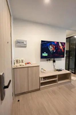 a living room with a flat screen tv on a wall at Modern Apartment with Pool & Gym in Kathu