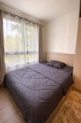 a bed in a bedroom with a large window at Modern Apartment with Pool & Gym in Kathu