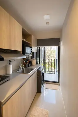 a small kitchen with a sink and a window at Modern Apartment with Pool & Gym in Kathu