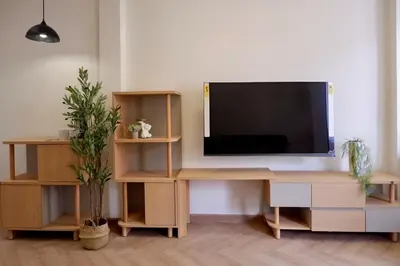 a living room with a television on a wooden desk at Tree House in Ban Rangeng