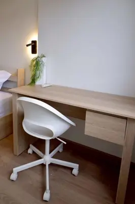 a desk with a white chair in a bedroom at Tree House in Ban Rangeng