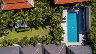 an aerial view of a resort with a swimming pool and palm trees at Greenleaf Estate - 3bedroom Villa with large shared pool, Nai harn beach in Rawai Beach