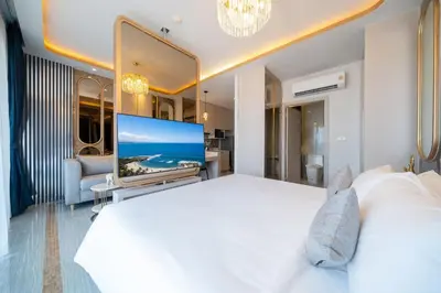 a bedroom with a large white bed and a flat screen tv at Apartment in Laguna perfect location in Laguna Phuket