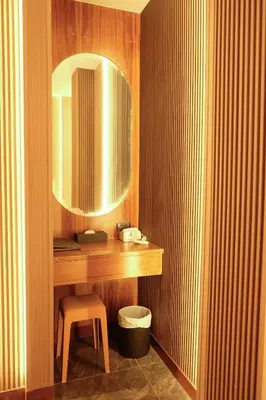 a bathroom with a vanity with a stool and a mirror at Bauman Residence in Patong Beach