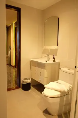 a white bathroom with a toilet and a sink at Bauman Residence in Patong Beach