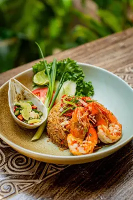 a plate of food with shrimp and vegetables on a table at Chaykha Retreat
