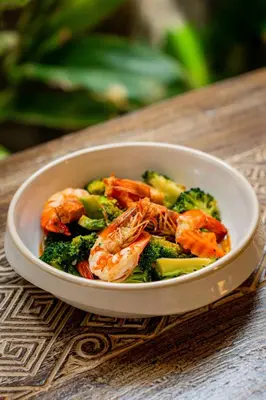 a bowl of shrimp and broccoli on a table at Chaykha Retreat