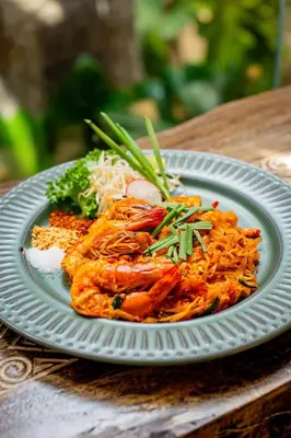 a plate of food with shrimp and vegetables on a table at Chaykha Retreat
