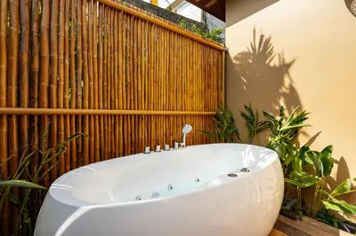 a bath tub in a bathroom with a wooden fence at Chaykha Retreat