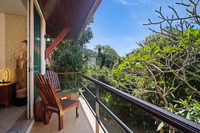 a porch with a rocking chair on a balcony at Kata Seaview Villa in Ban Karon
