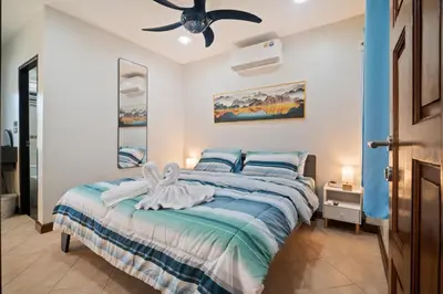 a bedroom with a bed and a ceiling fan at Kata Seaview Villa in Ban Karon