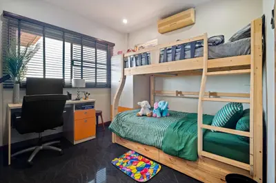 a bedroom with a bunk bed with a desk and a computer at Kata Seaview Villa in Ban Karon