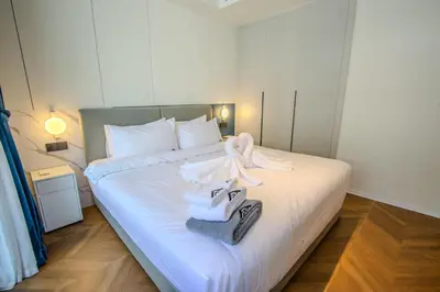a bedroom with a bed with towels on it at KORA 243 One-Bedroom Residence in Phuket Town