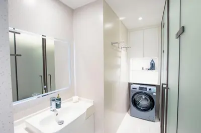a bathroom with a washing machine and a sink at KORA 243 One-Bedroom Residence in Phuket Town