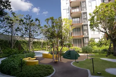 a garden with a playground in front of a building at Canvas 11112 Cozy 2BR Residence in Phuket Town