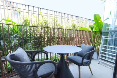 a patio with chairs and a table and a fence at Canvas 11112 Cozy 2BR Residence in Phuket Town