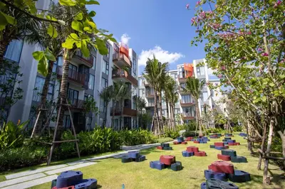 a park in front of some buildings with trees at Canvas 11112 Cozy 2BR Residence in Phuket Town