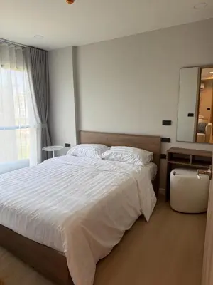 a bedroom with a large white bed and a mirror at Stylish 2BR condo in the heart of Bang Tao in Ban Thalat Choeng Thale