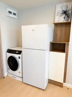 a white refrigerator and a washing machine in a room at Stylish 2BR condo in the heart of Bang Tao in Ban Thalat Choeng Thale