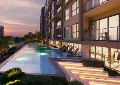 an exterior view of a building with a swimming pool at Stylish 2BR condo in the heart of Bang Tao in Ban Thalat Choeng Thale