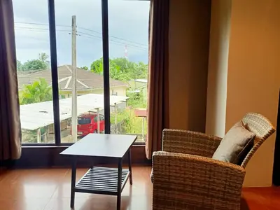 a living room with a table and chairs and a window at Arizona Residence in Ban Ko En