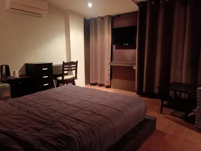 a bedroom with a bed and a table and a desk at Arizona Residence in Ban Ko En