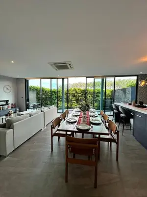 a dining room and living room with a table and chairs at Bangtao Family Villa with Pool in Ban Pak Lak