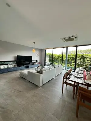 a large living room with white couches and a tv at Bangtao Family Villa with Pool in Ban Pak Lak