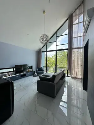 a living room with a couch and a large window at Bangtao Family Villa with Pool in Ban Pak Lak