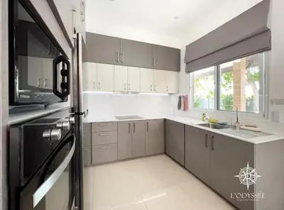 a kitchen with white cabinets and a black refrigerator at V292 Central Rawai Private Pool Villa with Amenities in Rawai Beach