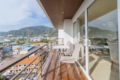 a balcony with a table and chairs and a view at C265 Great Ocean View 2BR Pool & Gym Near Beach in Patong Beach