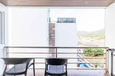 a balcony with two chairs and a large window at C265 Great Ocean View 2BR Pool & Gym Near Beach in Patong Beach