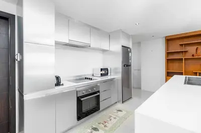 a white kitchen with a stove and a refrigerator at C265 Great Ocean View 2BR Pool & Gym Near Beach in Patong Beach