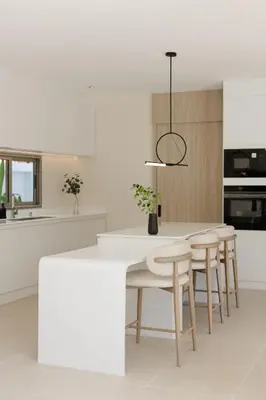 a white kitchen with a table and stools at Pool Villa Rawai, Phuket Lay Pearl in Ban Saiyuan (1)