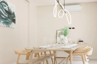 a white dining room with a wooden table and chairs at Pool Villa Rawai, Phuket Lay Pearl in Ban Saiyuan (1)
