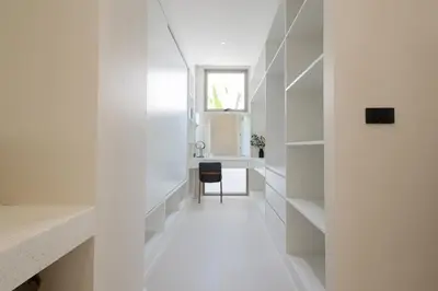 a hallway of a house with white walls and a chair at Pool Villa Rawai, Phuket Lay Pearl in Ban Saiyuan (1)