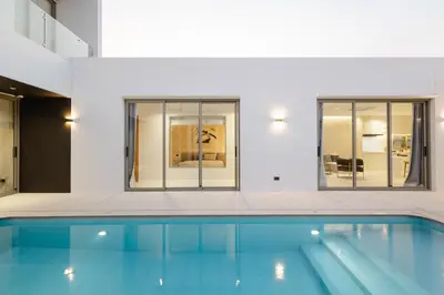 a swimming pool in a building with windows at Pool Villa Rawai, Phuket Lay Pearl in Ban Saiyuan (1)